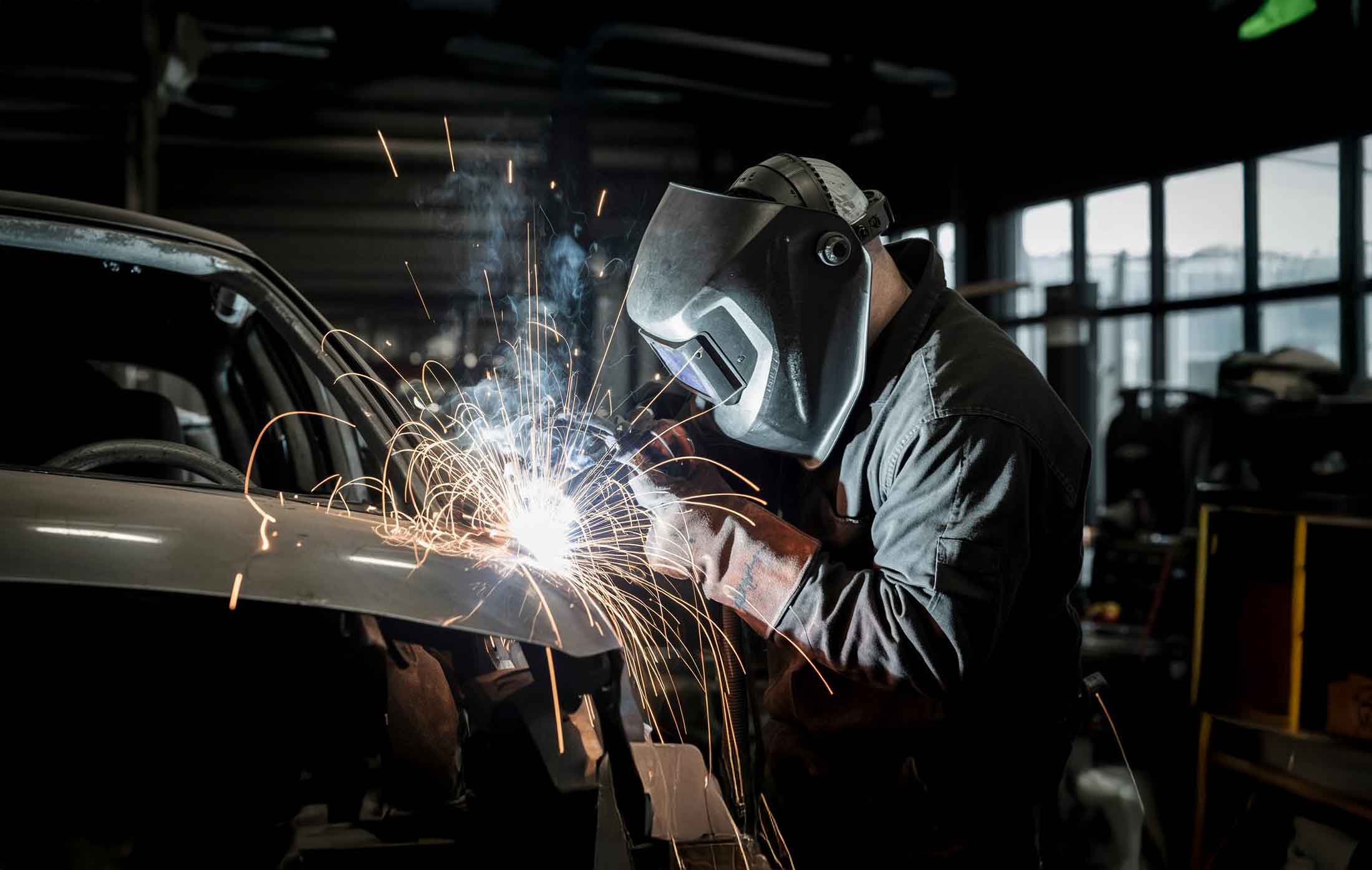 technician welding on front end of vehicle for repair - auto body repair - carrillo and sons collision center 