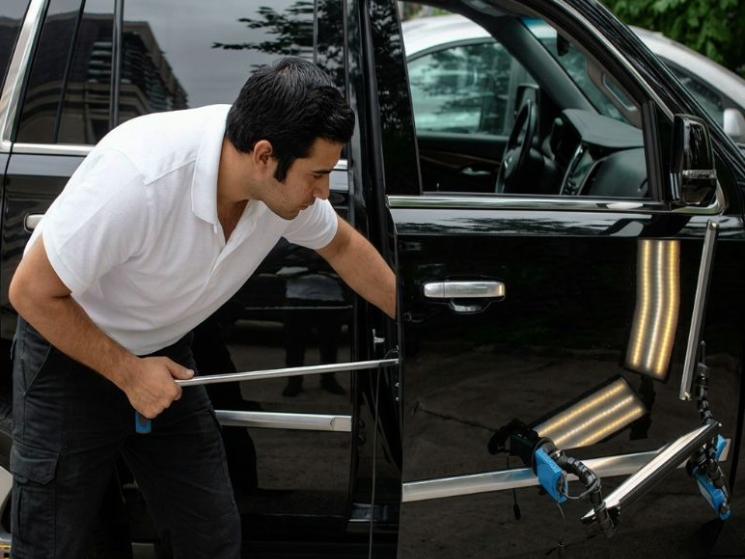 Paintless Dent Repair tech working on door